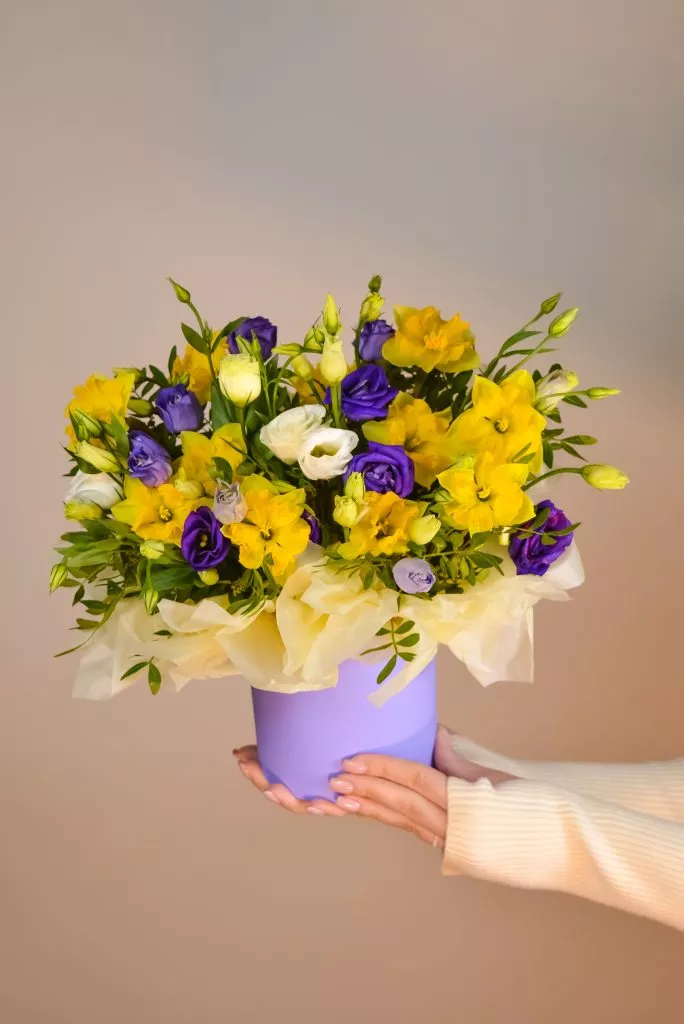 Композиция в шляпной коробке с эустомой, нарциссом и фисташкой