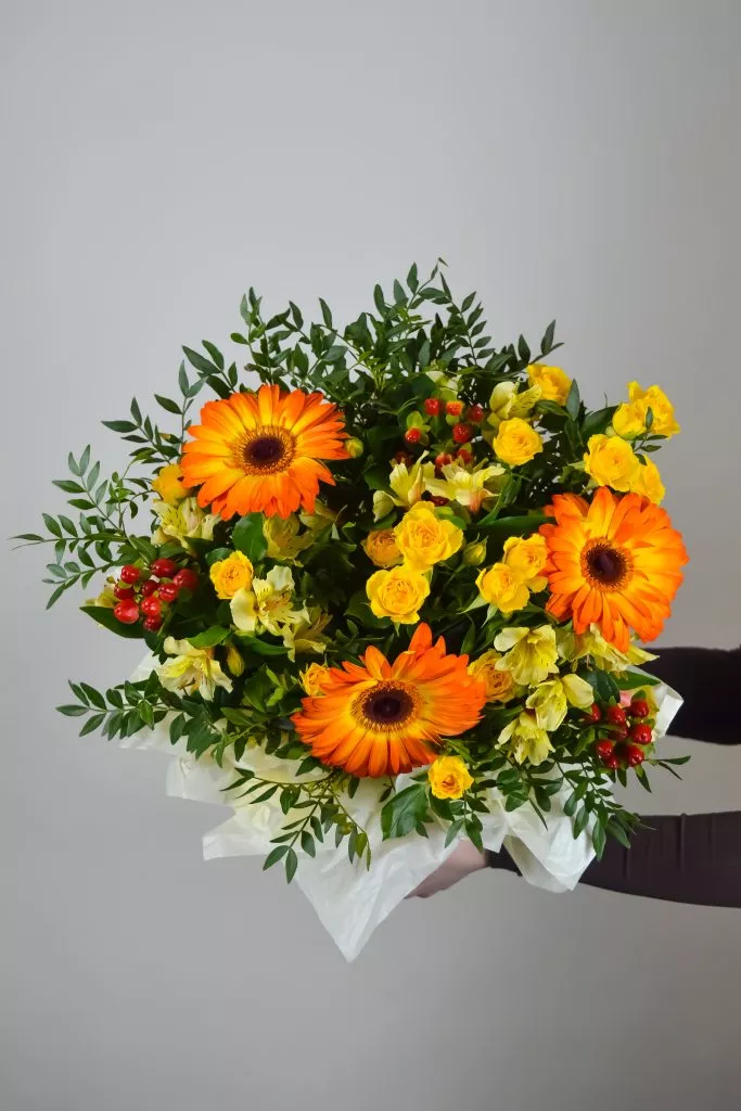 Композиция в шляпной коробке из гербер, гиперикума, альстромерии, кустовой розы и фисташки