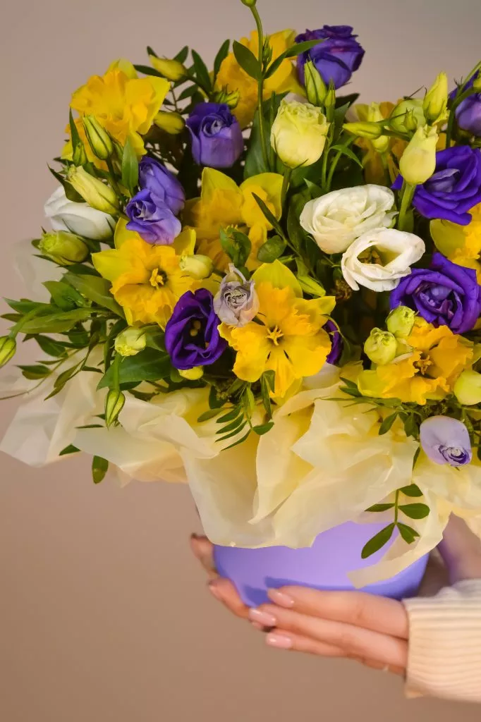 Композиция в шляпной коробке с эустомой, нарциссом и фисташкой