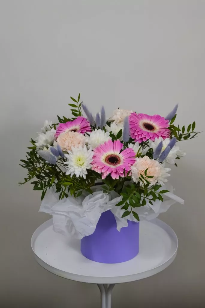 Композиция в шляпной коробке с герберами, кустовой хризантемой, гвоздикой, фисташкой и лагурусом