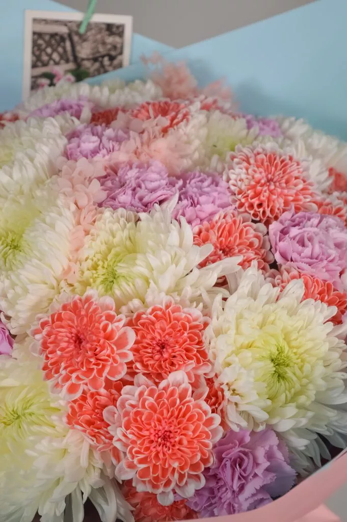 Сборный букет из Одноголовой хризантемы белого цвета,гвоздика одноголовая розовая,хризантема кустовая кораллового цвета в оформлении под ленту